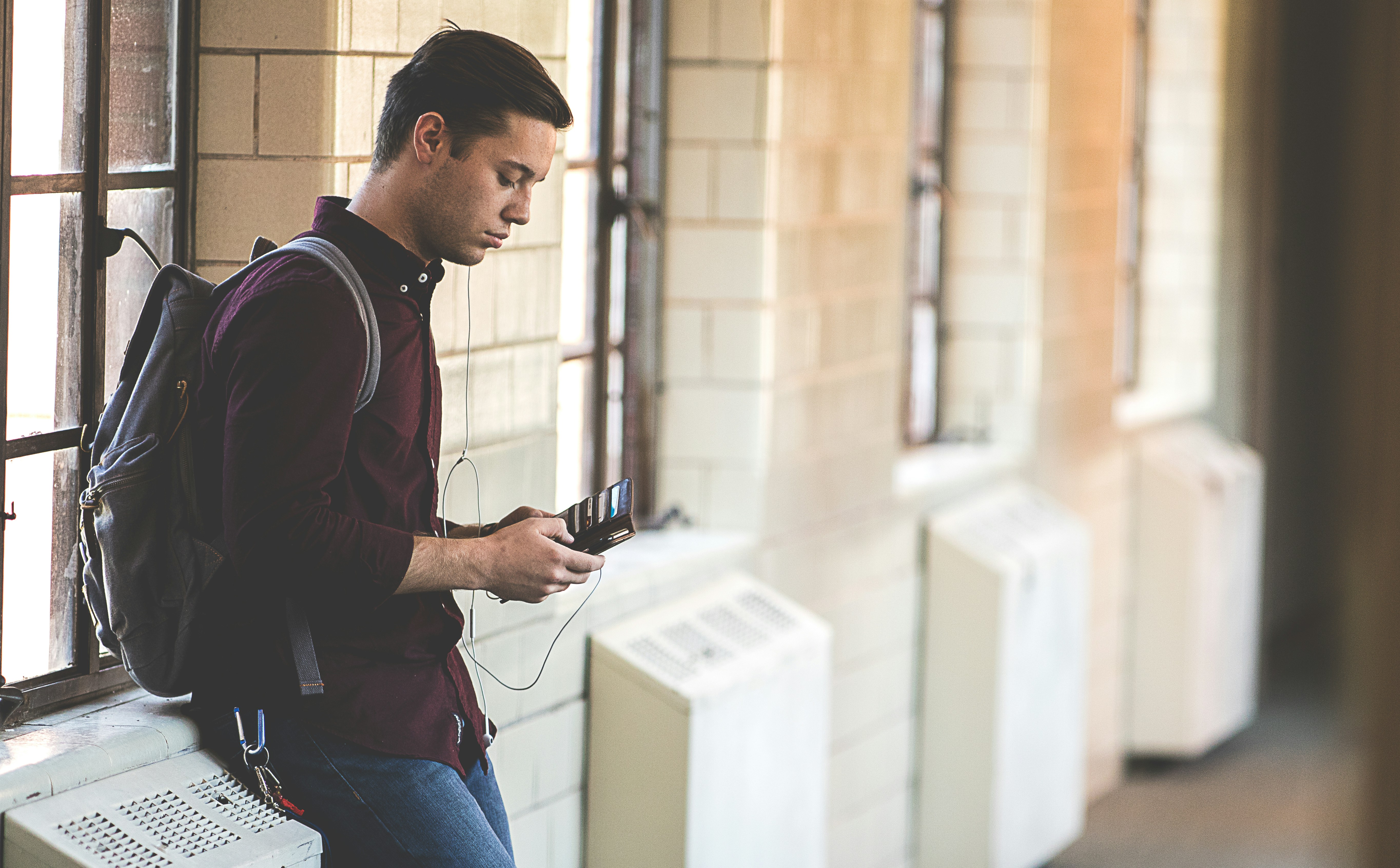 Junge im Schulgebäude mit Smartphone