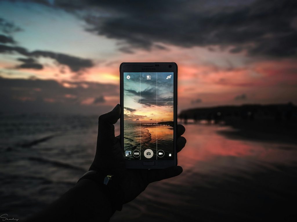 Handyfoto am Meer bei Sonnenuntergang